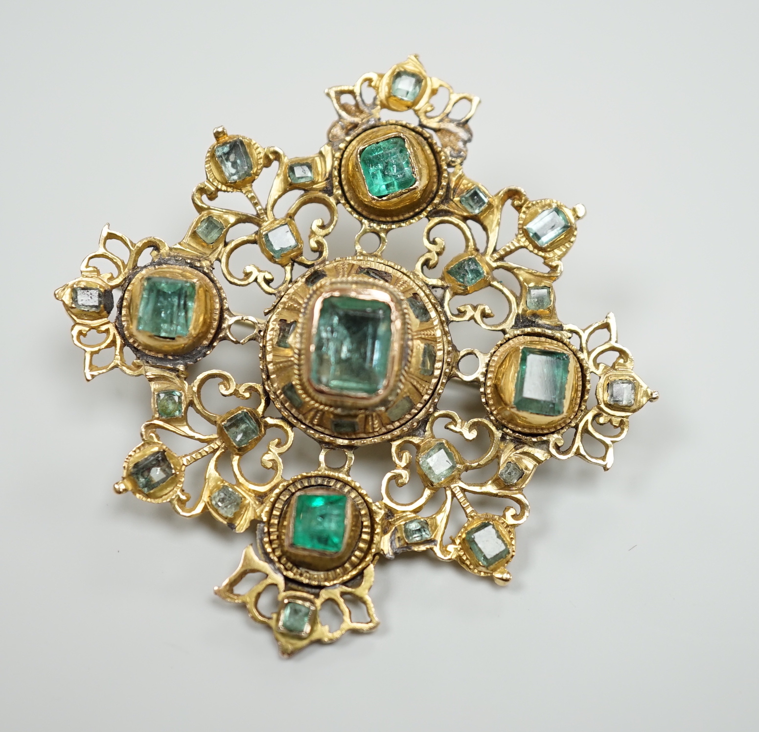 A 19th century continental pierced yellow metal and emerald cluster set quatrefoil brooch, 47mm